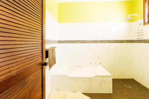 a bathroom with a white sink and a wooden door at Coal d' Vine VIEW - Cessnock NSW in Cessnock