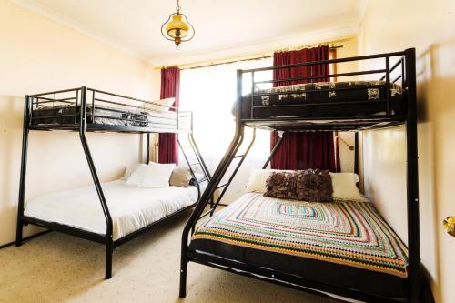 a bedroom with two bunk beds and a bed at Coal d' Vine VIEW - Cessnock NSW in Cessnock