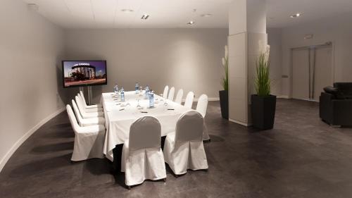 a dining room with a white table and white chairs at Eurostars Don Cándido in Terrassa