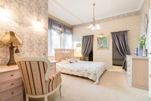 een slaapkamer met een bed en een stoel bij Royal in Rīga