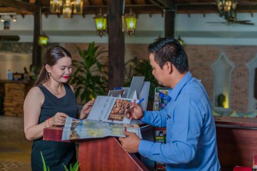 a man and a woman buying food at a counter at Mekong Angkor Deluxe Hotel in Siem Reap