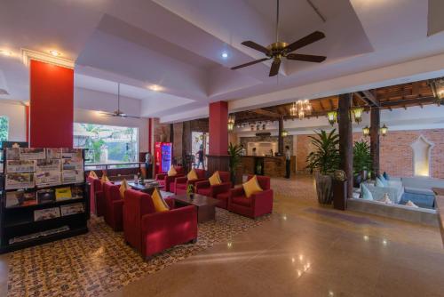 a living room with red chairs and a ceiling fan at Mekong Angkor Deluxe Hotel in Siem Reap