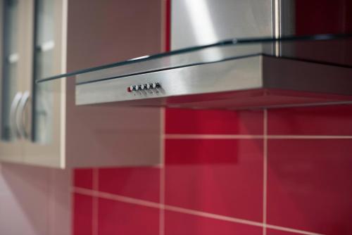 a glass counter top in a kitchen with red tiles at Midland Haven - Midland WA in Midland Junction
