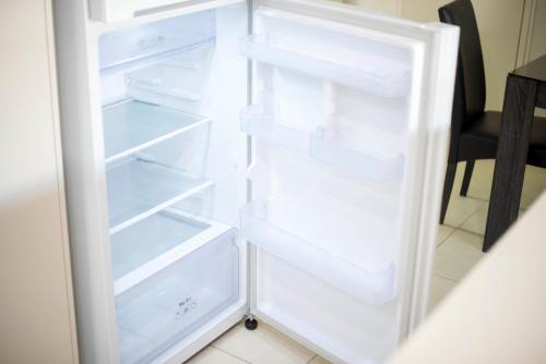 an empty refrigerator with its doors open in a kitchen at Midland Haven - Midland WA in Midland Junction