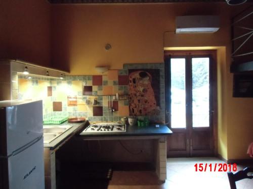a kitchen with a stove and a sink and a refrigerator at Holiday home Santa Flavia in Santa Flavia