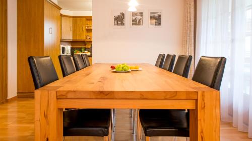 a dining room table with chairs and a bowl of fruit on it at Haus Alpenglück in Saas-Fee