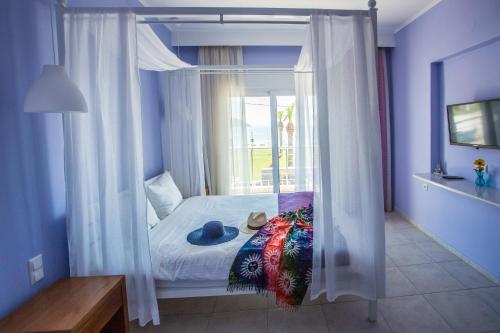 a bedroom with a canopy bed with a window at Sea to See in Néa Péramos