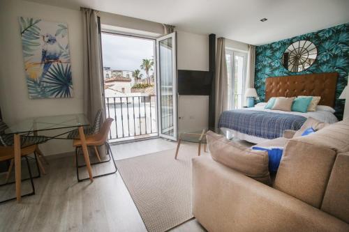 een woonkamer met een bed en een bank bij Apartamentos Soho Boutique Museo in Málaga