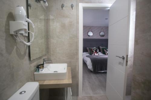 a bathroom with a sink and a bed in a room at Apartamentos Soho Boutique Museo in Málaga