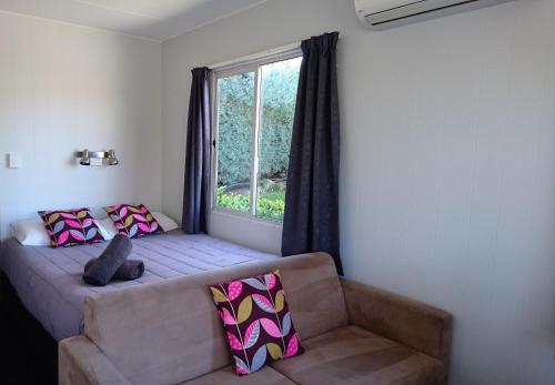 a living room with a couch and a window at Taupo Debretts Spa Resort in Taupo