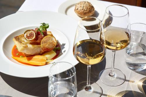 une assiette de nourriture sur une table avec des verres de vin dans l'établissement Relais des Trois Châteaux Hôtel-Restaurant - Teritoria, à Cour-Cheverny