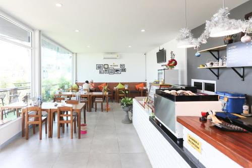 um restaurante com mesas e cadeiras em uma sala em The Garage em Chiang Rai