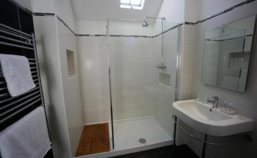 a white bathroom with a shower and a sink at The Staff Of Life in Ticknall