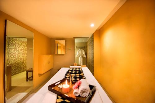 a room with a bed with two candles on it at The Suryaa New Delhi in New Delhi
