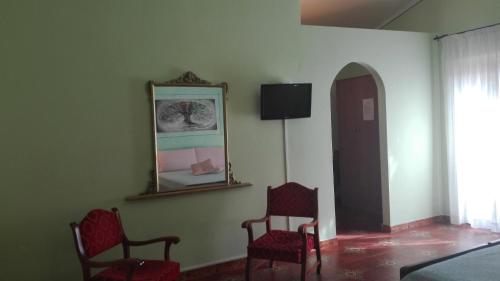 Zimmer mit 2 Stühlen und einem Spiegel an der Wand in der Unterkunft Agriturismo Monte Pino in Telti