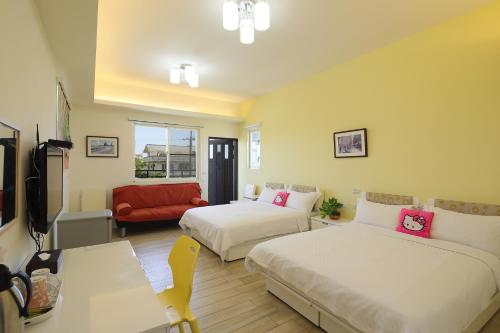 羅東鎮的住宿－蘭卡威羅東庭園民宿，酒店客房带两张床和一张红色沙发