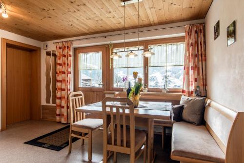 - une salle à manger avec une table, des chaises et un canapé dans l'établissement Haus Ambiatscha, à Sankt Gallenkirch