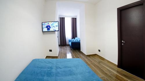 a room with a blue bed and a television at Beverello Suite in Naples