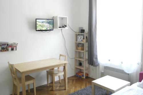 jadalnia ze stołem i telewizorem na ścianie w obiekcie City-Apartments Langegger w Wiedniu