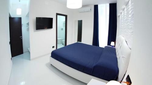 a bedroom with a blue bed and a mirror at Beverello Suite in Naples