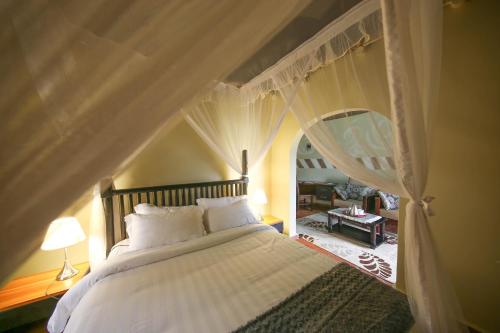 a bedroom with a white bed with a canopy at Victoria Forest Resort in Kalangala