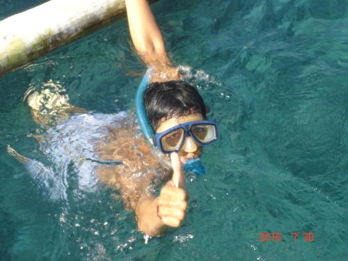 a person in a swimming pool with a snorkel at Penginapan Sedap Malam in Lovina