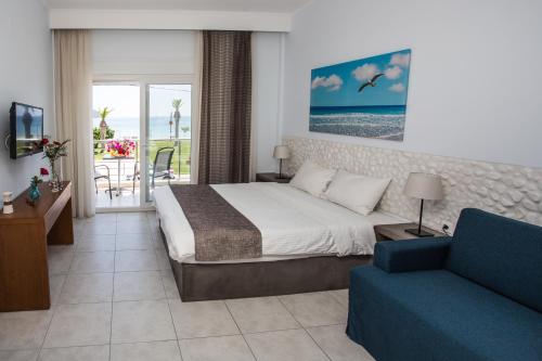um quarto de hotel com uma cama e um sofá em Sea to See em Nea Peramos