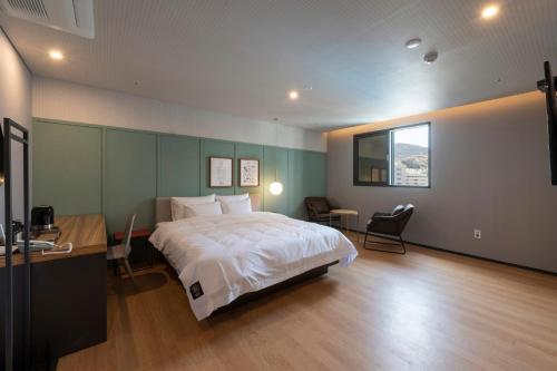 a bedroom with a bed and a desk and a window at Seomyeon Brown-dot hotel Gold in Busan