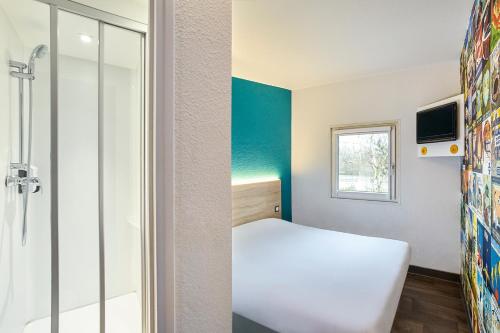 a small room with a bed and a shower at hotelF1 Bordeaux Ville in Bordeaux