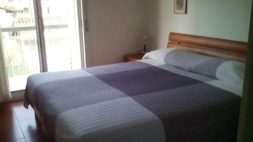 a bedroom with a bed with a blue and white blanket at Appartamento Perco Riva Dandolo in Grado