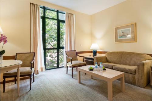 a living room with a couch and chairs and a table at Espahotel Plaza Basílica in Madrid