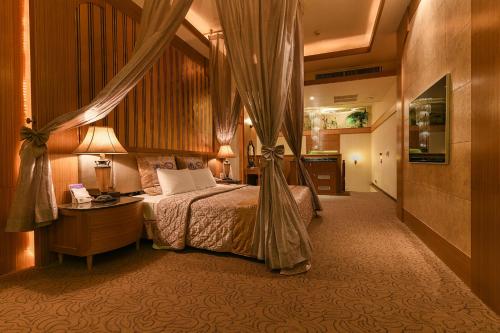 pokój hotelowy z łóżkiem, stołem i lampką w obiekcie Hwu Meei Motel w mieście Tainan