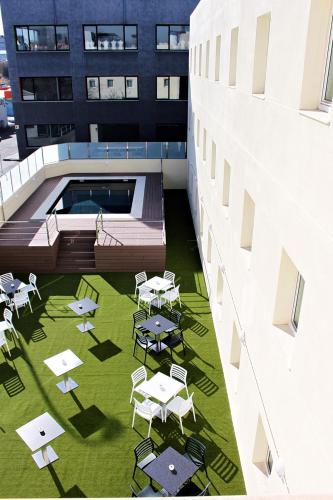 a courtyard with tables and chairs on a building at Checkin Urban Nevada in Granada