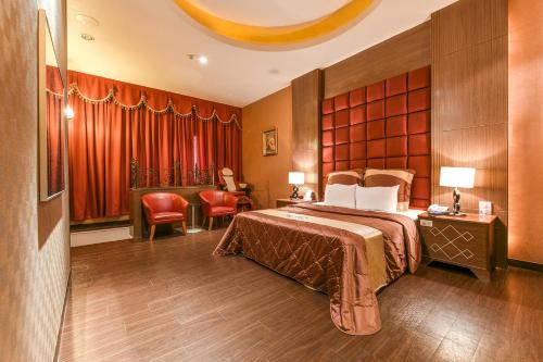 a hotel room with a bed and a chair at Hwu Meei Motel in Tainan