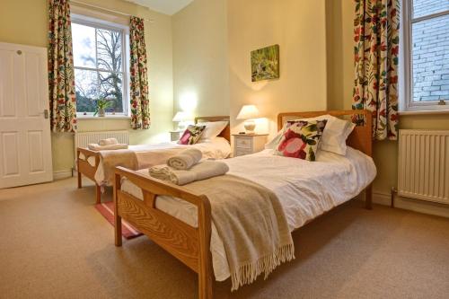 Un dormitorio con dos camas y una ventana. en Grosmont House, en Grosmont