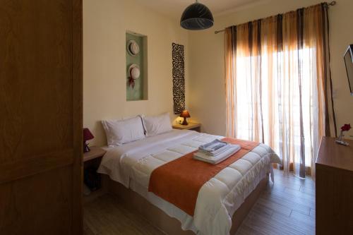 a bedroom with a bed and a large window at Sea to See in Néa Péramos