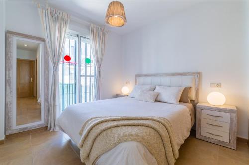 a white bedroom with a bed and a mirror at Chalet Parque Tecnológico in Campanillas