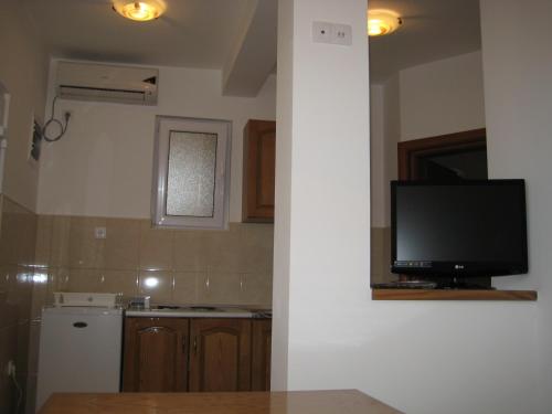 a kitchen with a flat screen tv on a wall at Apartments Stanjević in Tivat