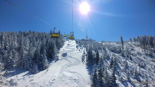 a ski lift going down a snow covered mountain at Mała Osada domki z jacuzzi przy gondoli in Szczyrk
