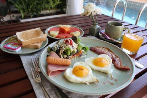 two plates of breakfast food on a table at Kampaeng Ngam Hotel in Chiang Mai