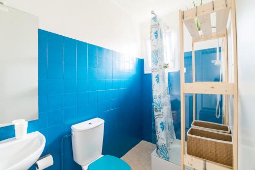 a blue bathroom with a toilet and a shower at Le Studio Bleu de la gare in Vieux-Boucau-les-Bains