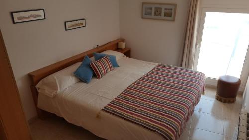 Un dormitorio con una cama grande con almohadas azules. en Apartament Enginy Llançà, en Llançà