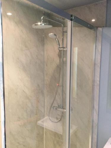 une douche avec une porte vitrée dans une salle de bain dans l'établissement La Porcherie, à Saint-Sernin