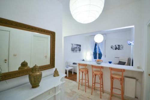 un soggiorno con specchio e bancone con sgabelli di Holiday Home Santa Margherita Ligure a Santa Margherita Ligure