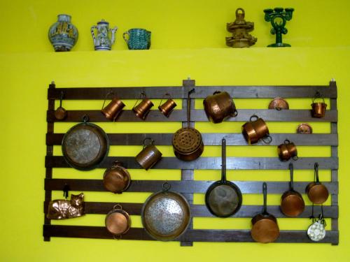 a bunch of pots and pans hanging on a wall at Lirma B&B in Cefalù