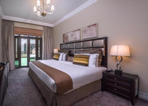 a large bedroom with a large bed and a chandelier at Downtown Al Bahar Apartments in Dubai