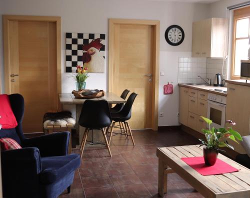 uma cozinha e sala de estar com mesa e cadeiras em Apartments Waldemar em Saalfelden am Steinernen Meer