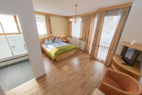 ein Hotelzimmer mit einem Bett und einem TV in der Unterkunft Hotel Naggler Weissbriach in Weissbriach