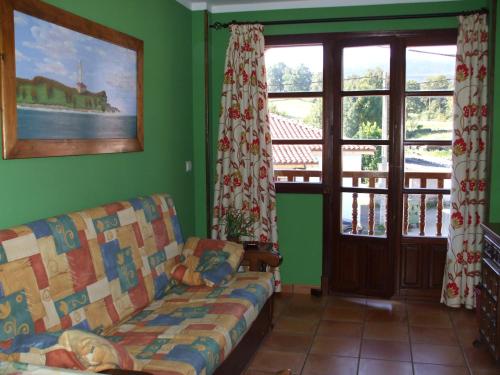 a living room with a couch and some windows at Apartamentos La Corraliza in Totero