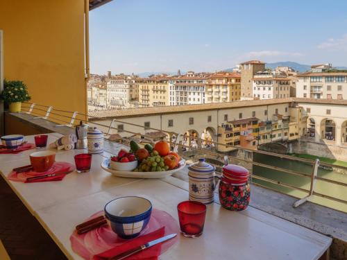 a table with a bowl of fruit and a view of a city at Ponte Vecchio Terrace in Florence